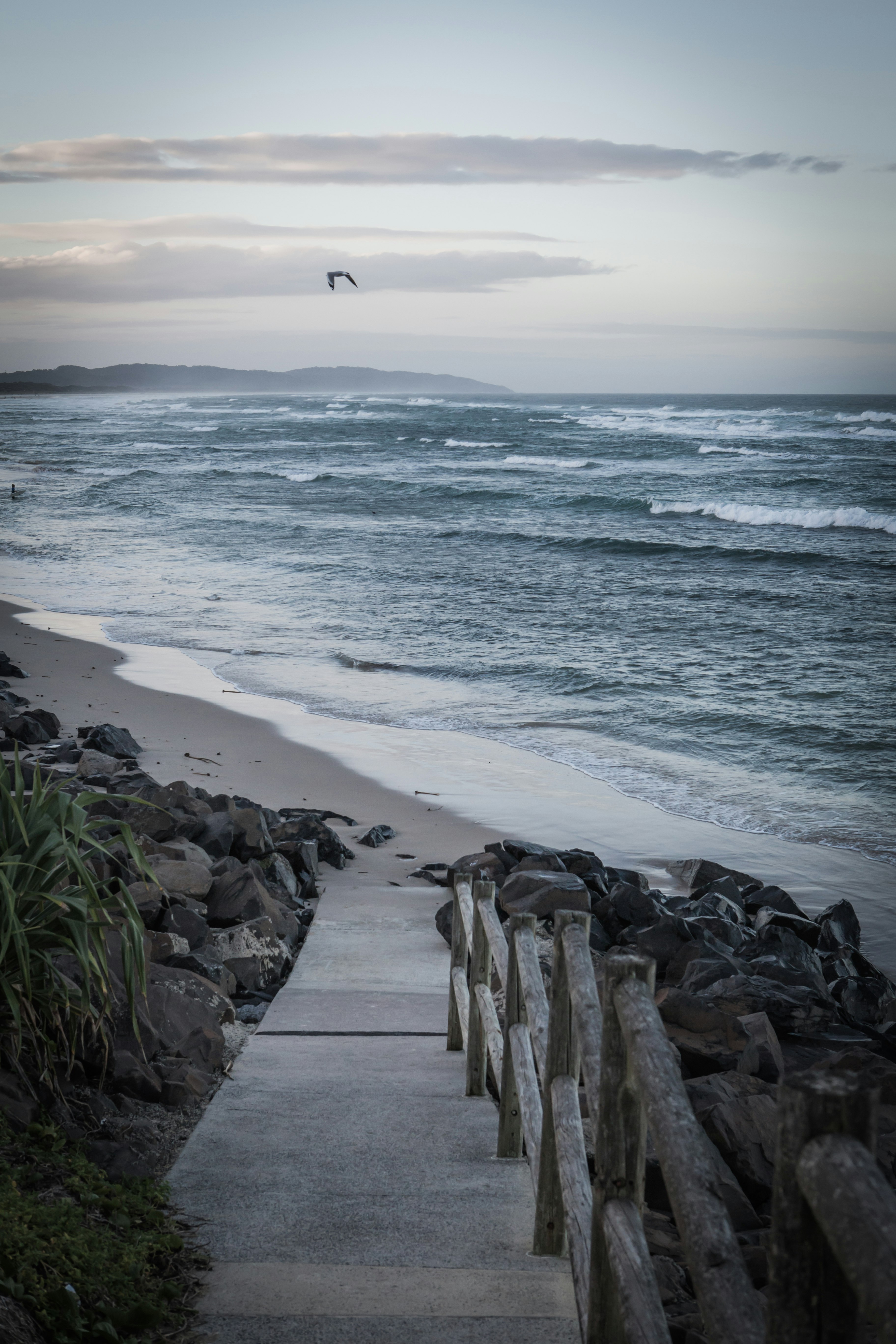 stair on seashore near mountain range